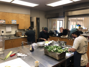 people prepping food in a large kitchen