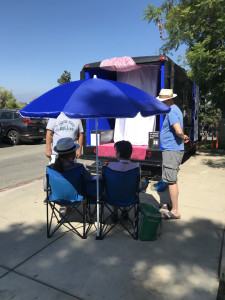 sitting in camp chairs outside of Gas gallery, parked