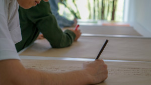 2 people writing on craft paper