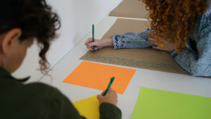 2 people writing on craft paper