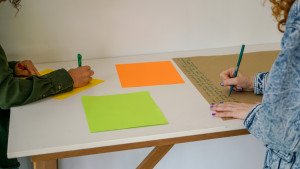 2 people writing on paper