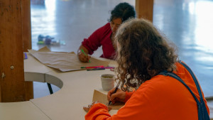 2 people writing on craft paper